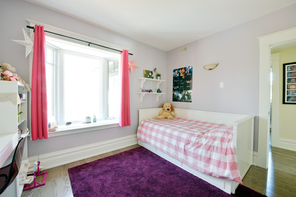 Esempio di una cameretta per bambini da 4 a 10 anni classica di medie dimensioni con pareti viola e parquet chiaro