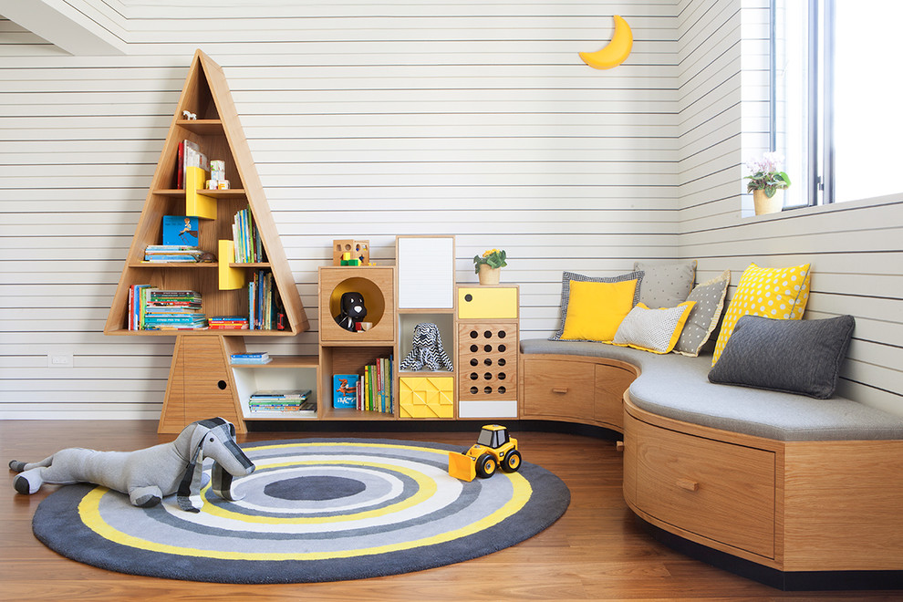 Exemple d'une salle de jeux d'enfant de 4 à 10 ans tendance avec un mur multicolore, un sol en bois brun et un sol marron.