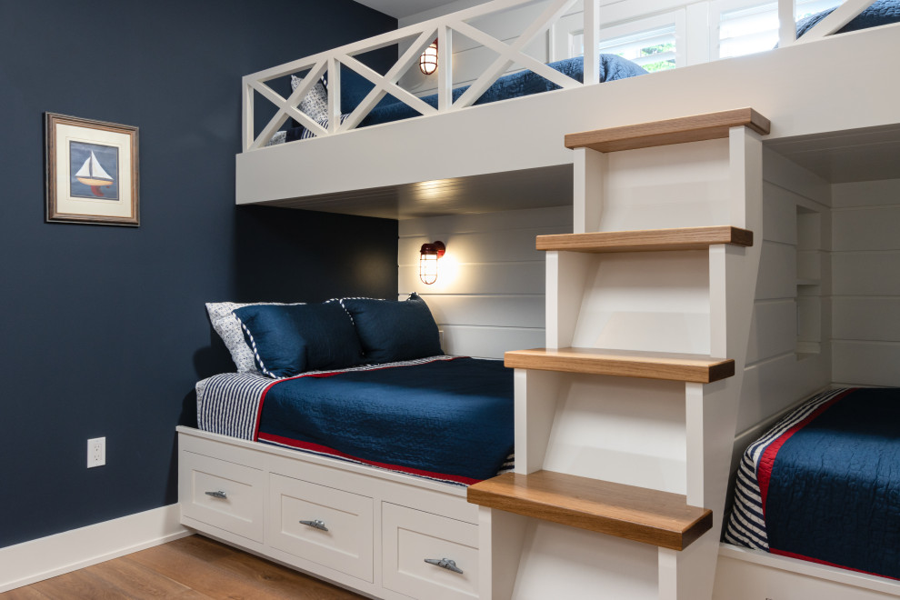 Imagen de dormitorio infantil costero con paredes azules, suelo de madera en tonos medios y suelo marrón