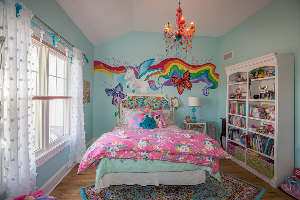 Idée de décoration pour une chambre d'enfant de 4 à 10 ans bohème de taille moyenne avec un mur bleu, un sol en bois brun et un sol marron.