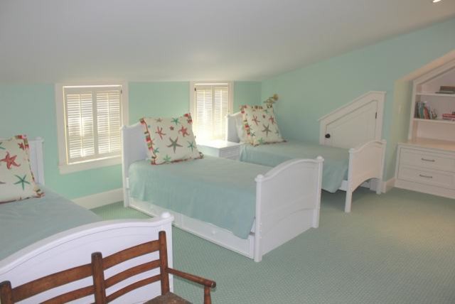 Large nautical children’s room for girls in Boston with carpet, blue walls and blue floors.