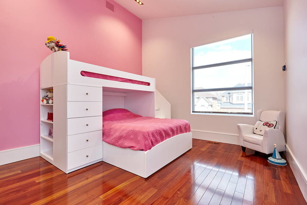 Inspiration pour une grande chambre d'enfant de 4 à 10 ans minimaliste avec un mur rose et un sol en bois brun.