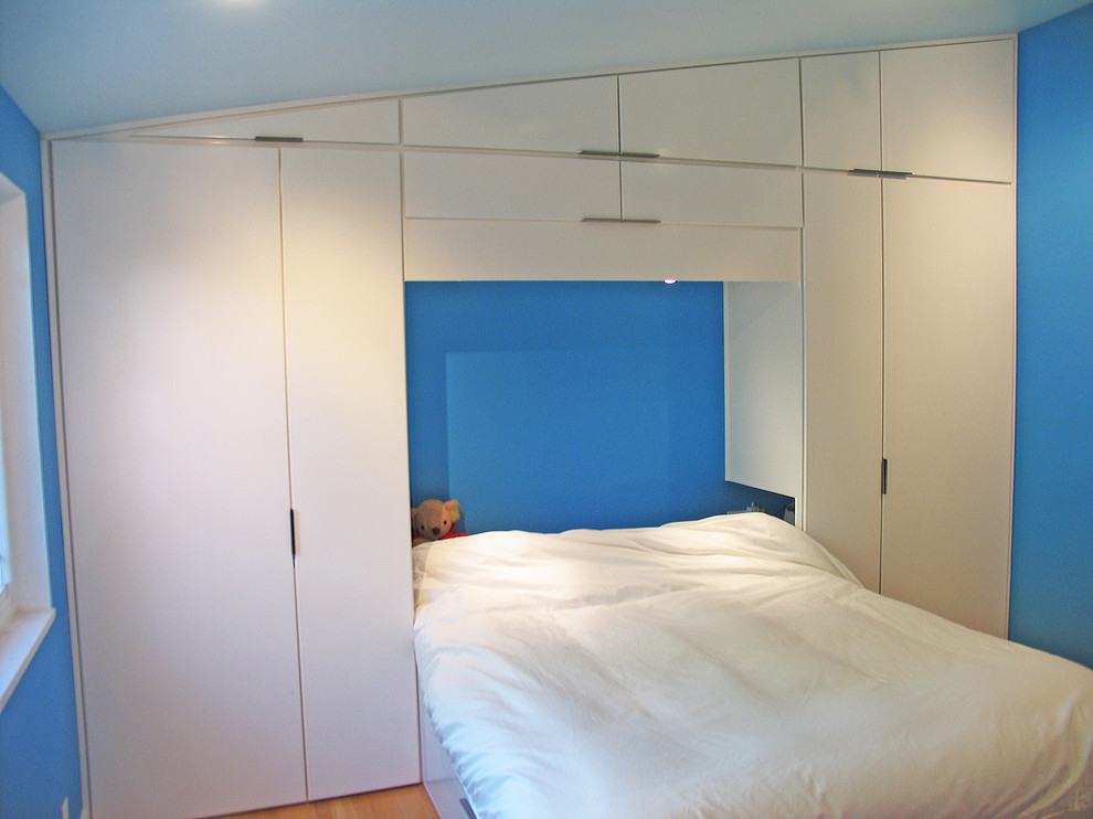 Mittelgroßes Modernes Schlafzimmer mit blauer Wandfarbe, hellem Holzboden und braunem Boden in Hawaii