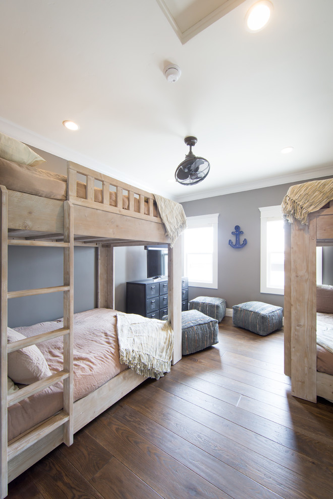 Diseño de dormitorio infantil costero pequeño con paredes grises y suelo de madera en tonos medios