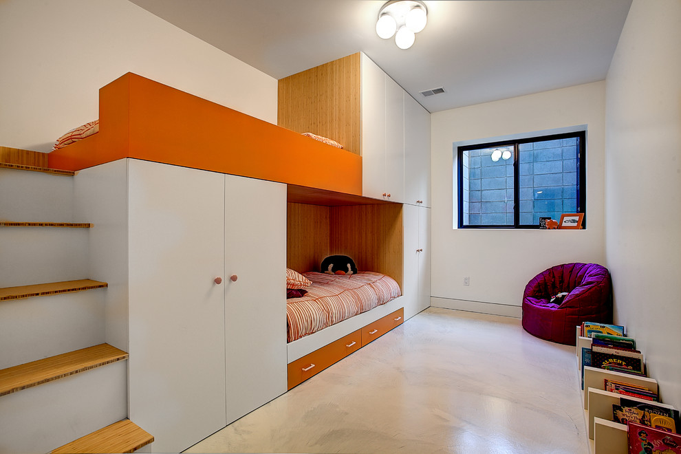 Exempel på ett stort modernt könsneutralt barnrum kombinerat med sovrum och för 4-10-åringar, med vita väggar och betonggolv