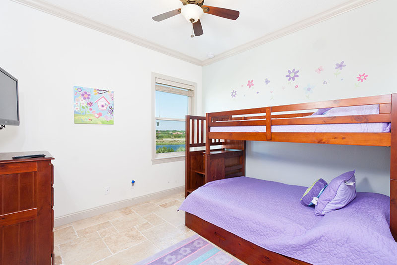 Idée de décoration pour une grande chambre d'enfant marine avec un mur blanc et un sol en travertin.
