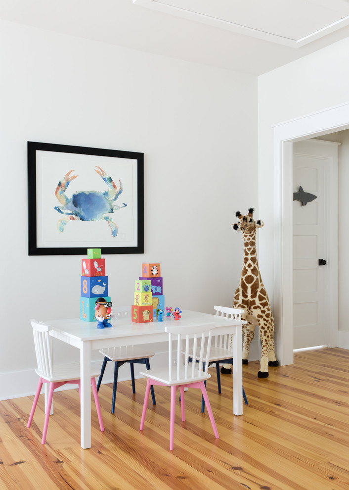 Esempio di una cameretta per bambini chic di medie dimensioni con pareti bianche, pavimento in legno massello medio e pavimento beige