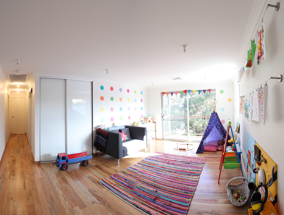Idées déco pour une grande salle de jeux d'enfant contemporaine avec un mur blanc et un sol en bois brun.