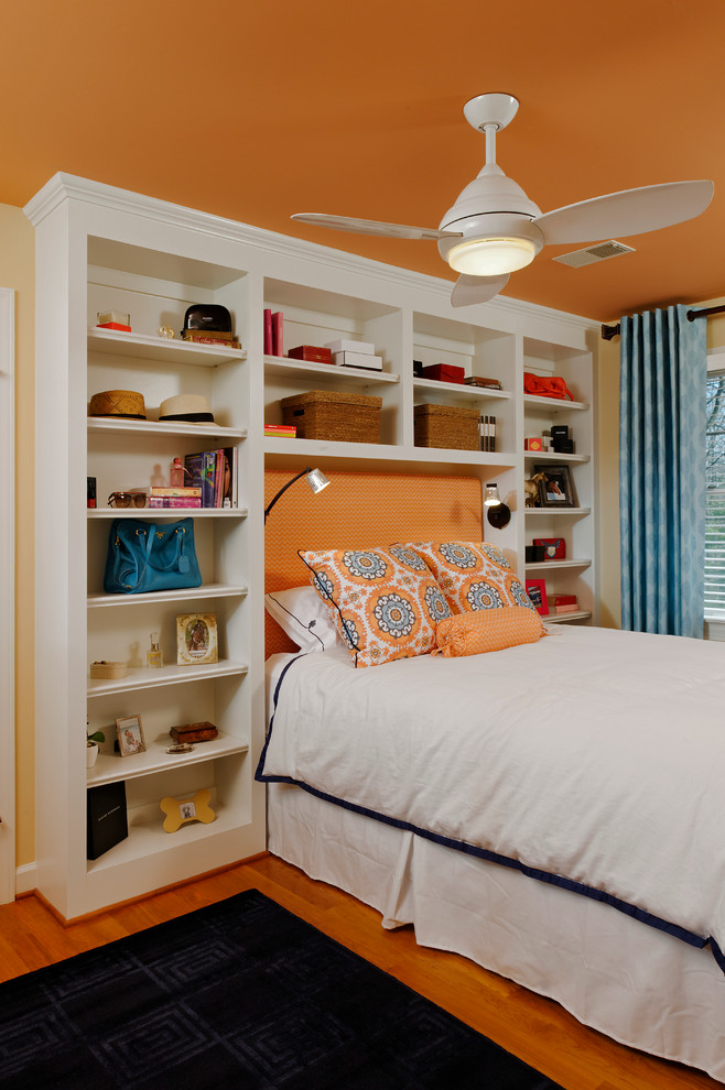 Cette photo montre une chambre d'enfant chic avec un mur orange et un sol en bois brun.