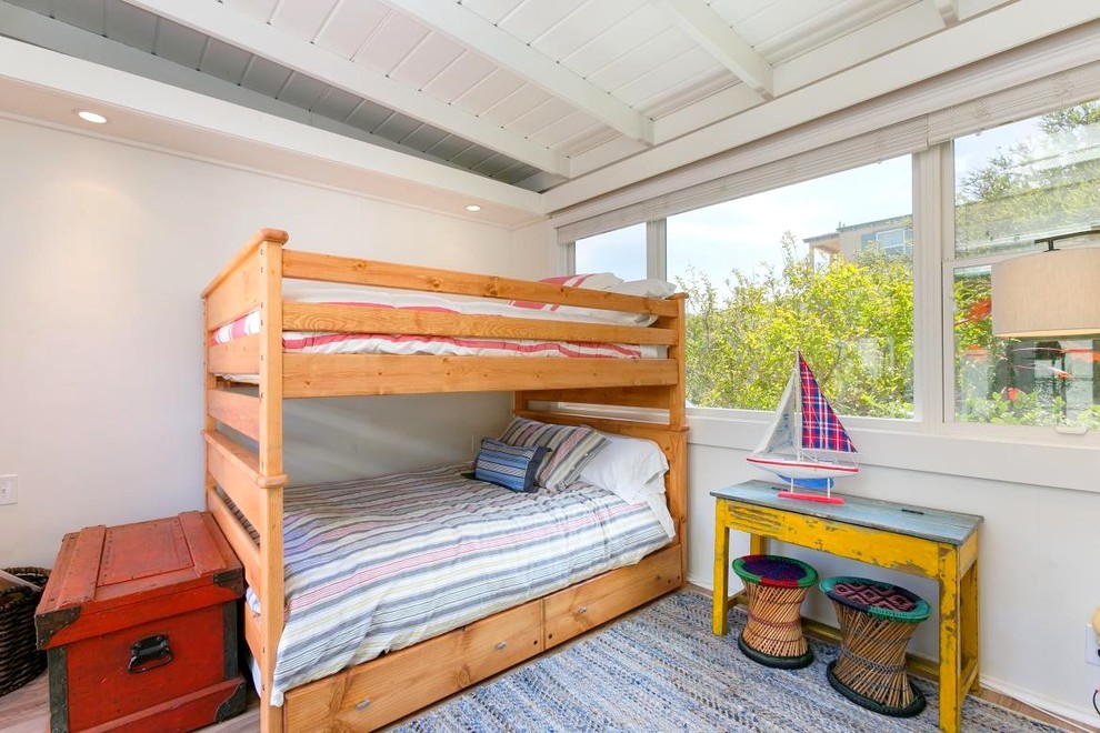Diseño de dormitorio infantil costero de tamaño medio con paredes blancas y suelo de madera clara
