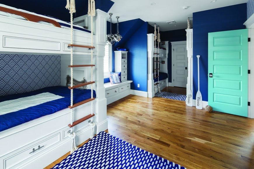 Foto på ett stort maritimt könsneutralt barnrum kombinerat med sovrum och för 4-10-åringar, med blå väggar, mellanmörkt trägolv och brunt golv