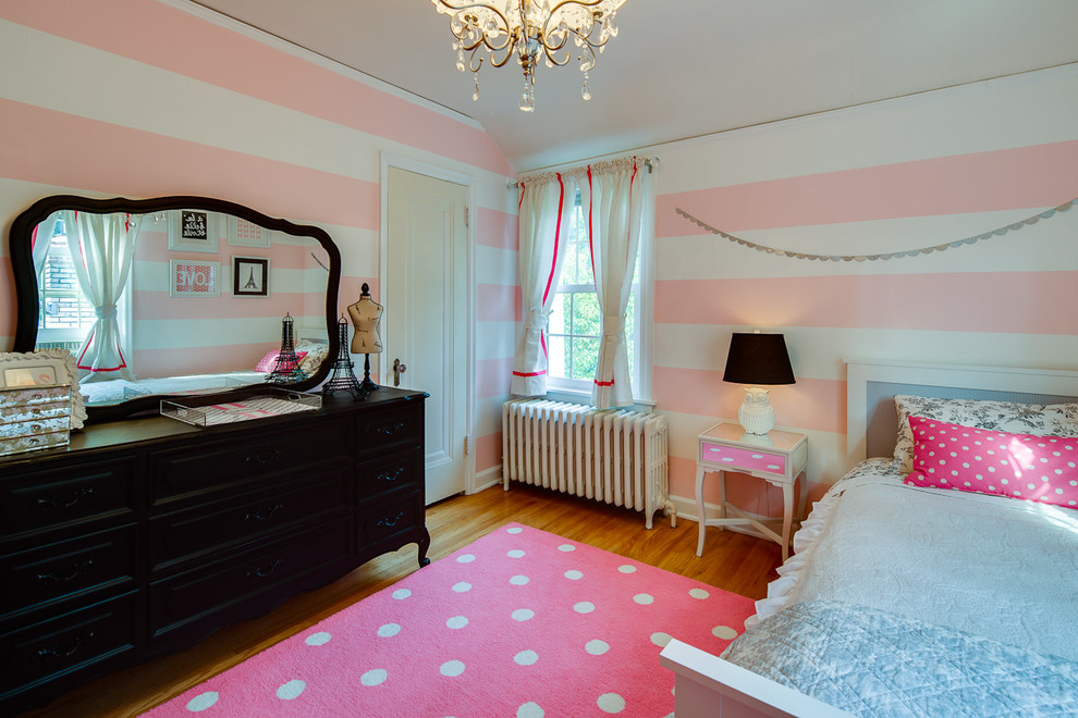 Imagen de dormitorio infantil actual con suelo de madera en tonos medios y paredes multicolor