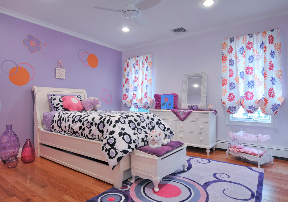 Aménagement d'une grande chambre d'enfant de 4 à 10 ans contemporaine avec un mur violet et un sol en bois brun.