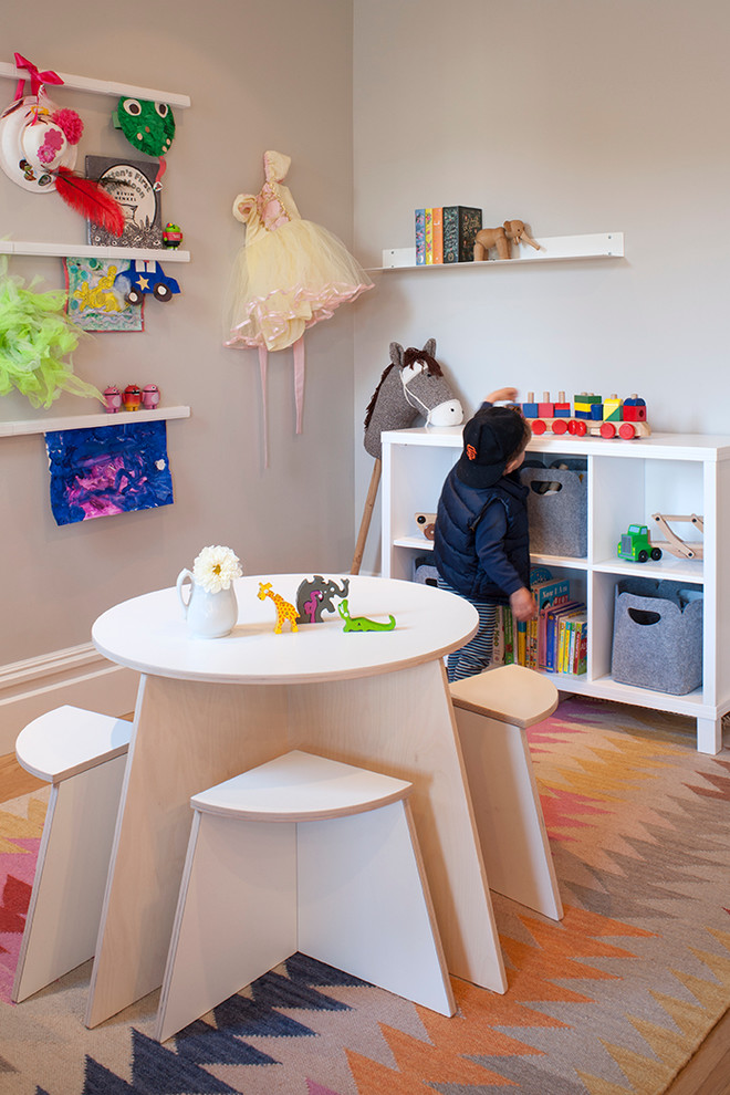 Cette photo montre une petite chambre d'enfant de 1 à 3 ans moderne avec un mur gris et parquet clair.