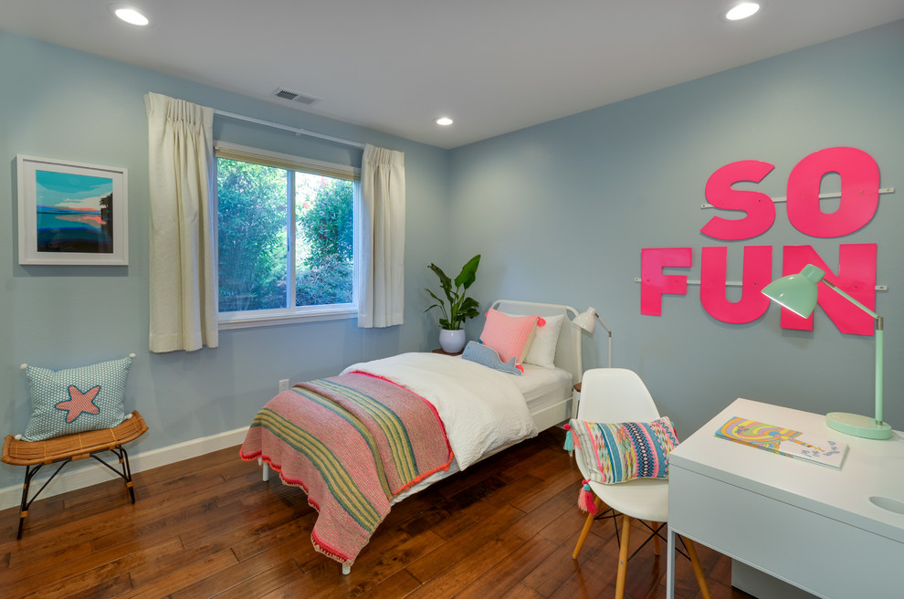 Immagine di una cameretta per bambini da 4 a 10 anni costiera di medie dimensioni con pareti blu e pavimento in legno massello medio