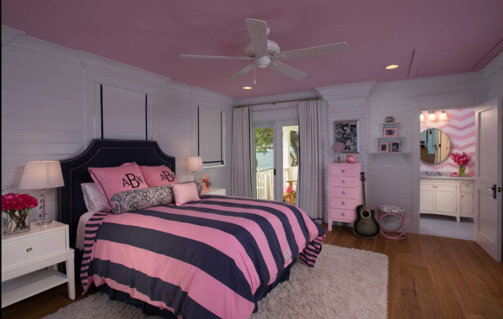 Foto de dormitorio infantil actual de tamaño medio con paredes rosas, suelo de madera en tonos medios y suelo marrón