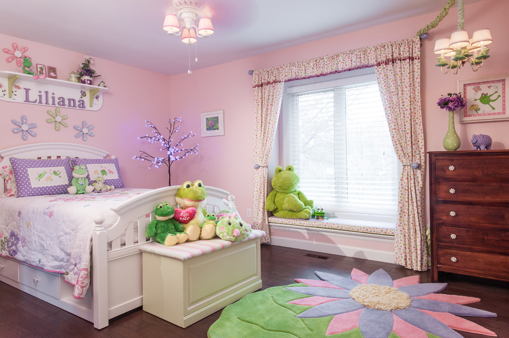 Réalisation d'une chambre d'enfant tradition avec un mur rose et parquet foncé.