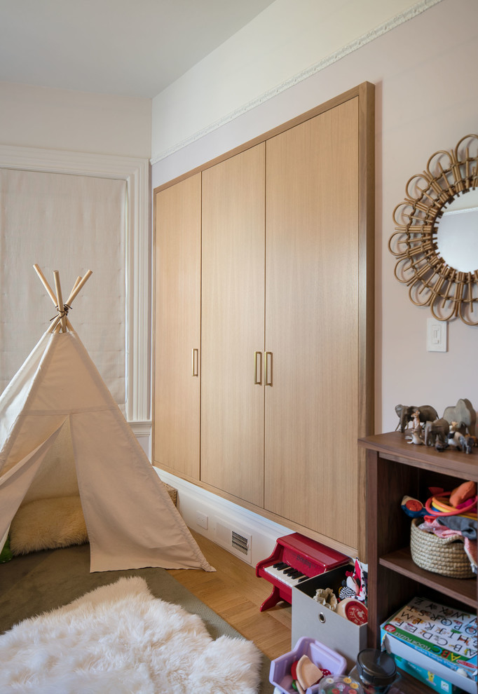 Inspiration pour une chambre d'enfant de 1 à 3 ans design de taille moyenne avec un mur blanc, un sol en bois brun et un sol marron.