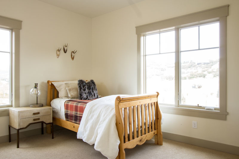 Cette image montre une grande chambre d'enfant chalet avec un mur beige et moquette.