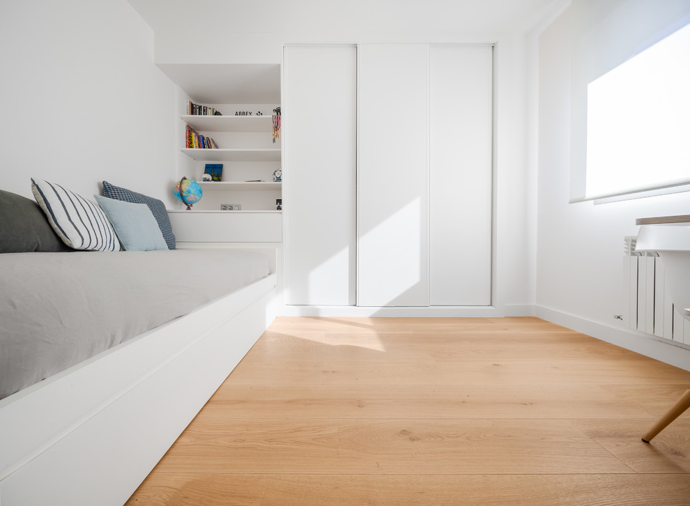 Cette image montre une chambre d'enfant nordique de taille moyenne avec un mur blanc et parquet clair.
