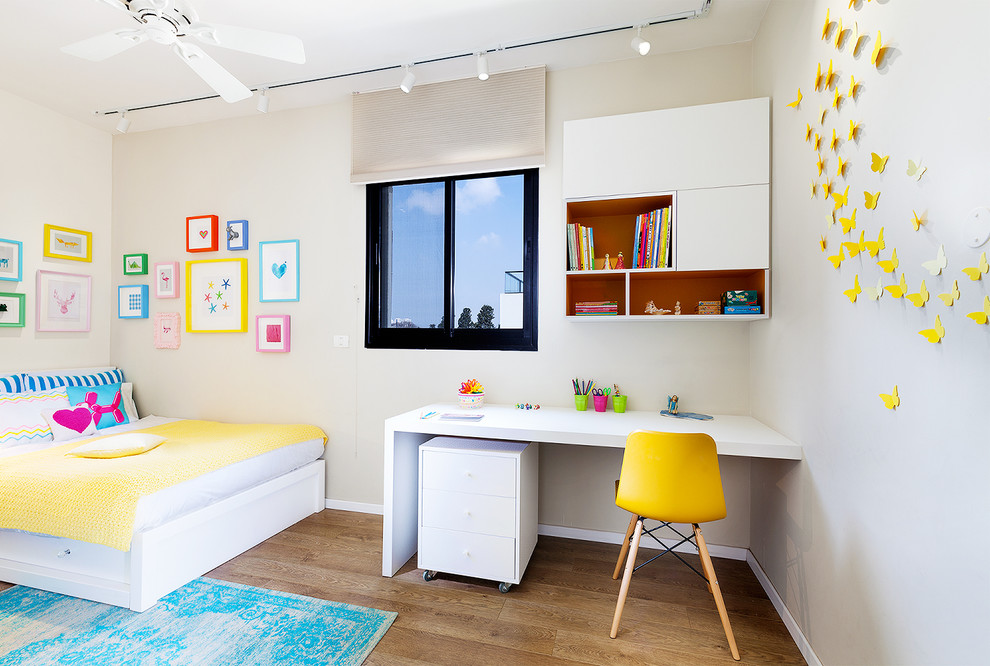 Ejemplo de dormitorio infantil de 4 a 10 años minimalista de tamaño medio con paredes multicolor, suelo laminado y suelo marrón