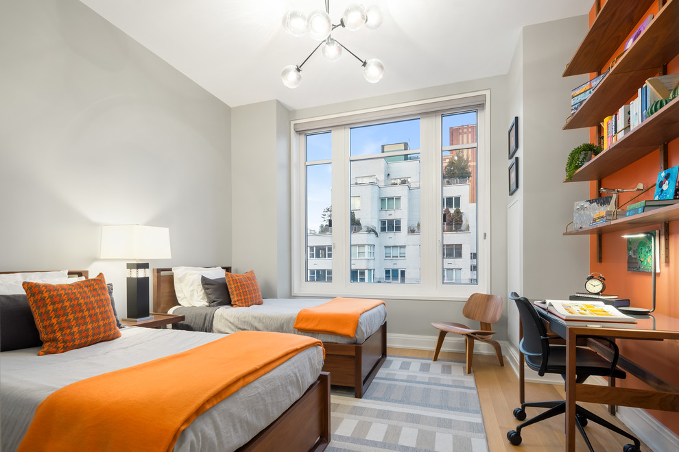 This is an example of a contemporary gender neutral teen’s room in New York with orange walls, light hardwood flooring and brown floors.