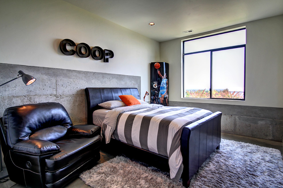 This is an example of an urban teen’s room for boys in Boise with beige walls and concrete flooring.