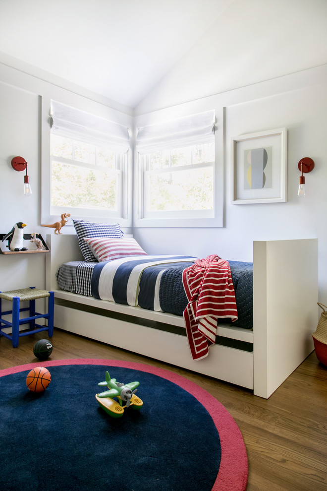 Esempio di una cameretta per bambini da 4 a 10 anni stile marinaro di medie dimensioni con pareti bianche e pavimento in legno massello medio