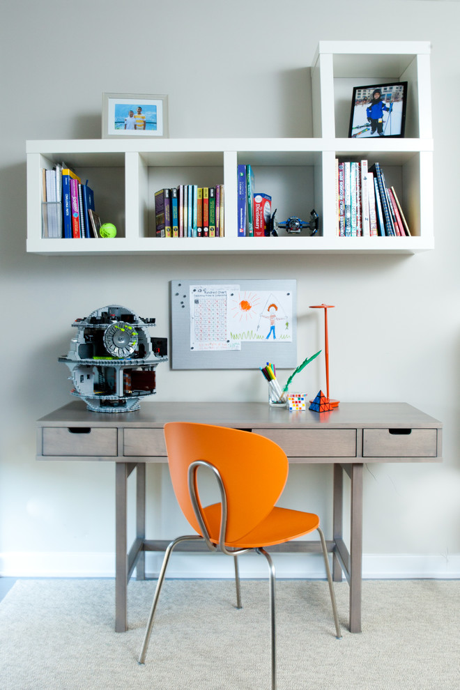 Modern inredning av ett pojkrum kombinerat med skrivbord, med vita väggar och heltäckningsmatta