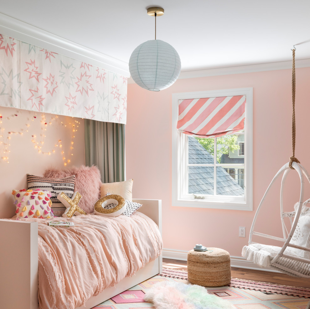 Ejemplo de dormitorio infantil tradicional renovado con paredes rosas, suelo de madera en tonos medios y suelo marrón