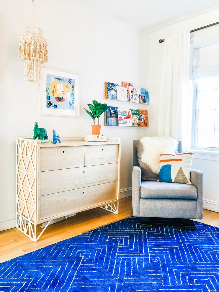 Foto på ett litet minimalistiskt pojkrum kombinerat med sovrum och för 4-10-åringar, med flerfärgade väggar, ljust trägolv och brunt golv
