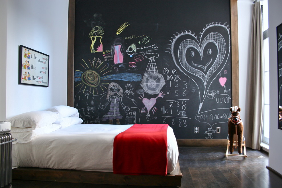 This is an example of an eclectic gender neutral children’s room in Toronto with dark hardwood flooring.