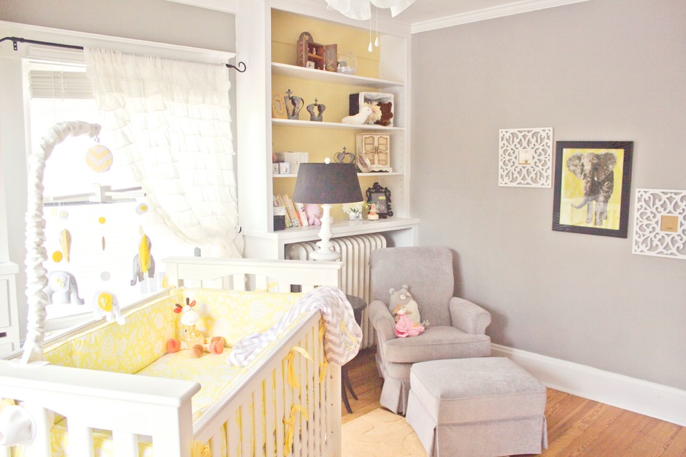 Ejemplo de dormitorio infantil de 1 a 3 años clásico pequeño con paredes grises y suelo de madera en tonos medios