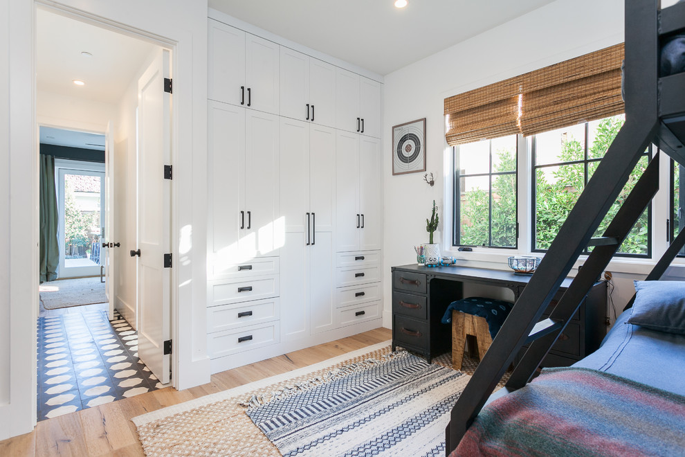 Modelo de dormitorio infantil de estilo de casa de campo con paredes blancas, suelo de madera en tonos medios y suelo beige