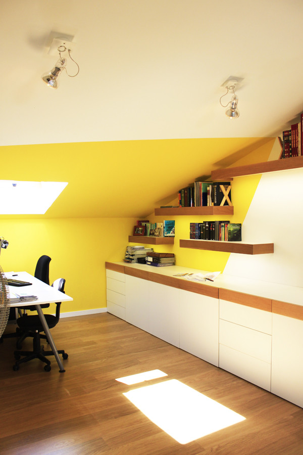 Modelo de habitación infantil unisex de 4 a 10 años moderna de tamaño medio con paredes amarillas, suelo de madera clara y escritorio