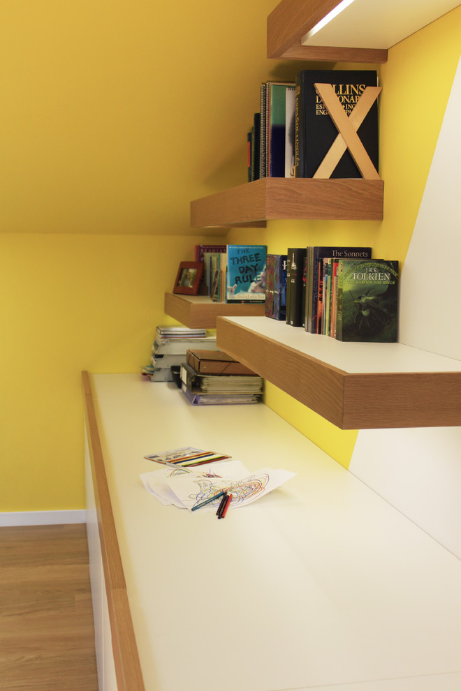 На фото: нейтральная детская среднего размера в стиле модернизм с желтыми стенами, светлым паркетным полом и рабочим местом для ребенка от 4 до 10 лет с