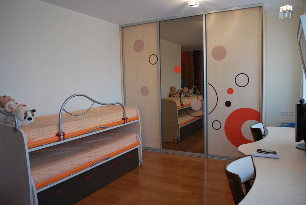 Idéer för ett modernt könsneutralt barnrum kombinerat med sovrum, med mellanmörkt trägolv