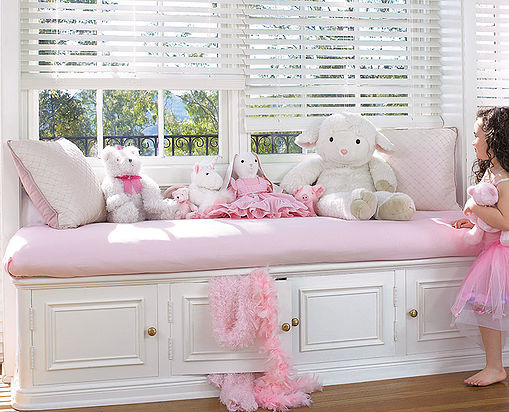 Modelo de dormitorio infantil de 1 a 3 años clásico de tamaño medio con paredes blancas y suelo de madera en tonos medios