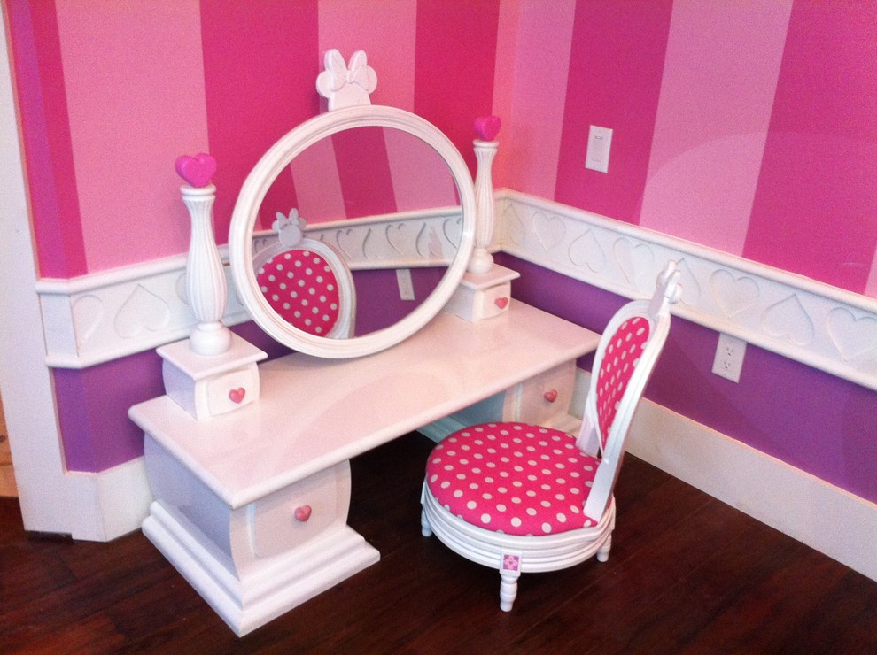 Medium sized traditional children’s room for girls with pink walls, dark hardwood flooring and brown floors.
