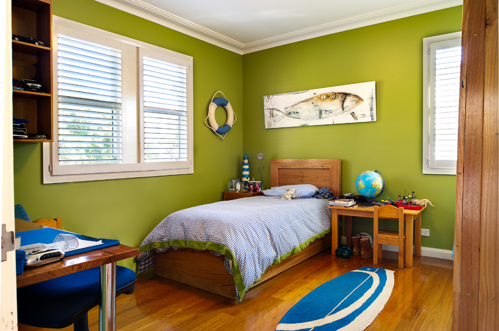 Cette image montre une chambre d'enfant de 4 à 10 ans marine avec un mur vert et un sol en bois brun.