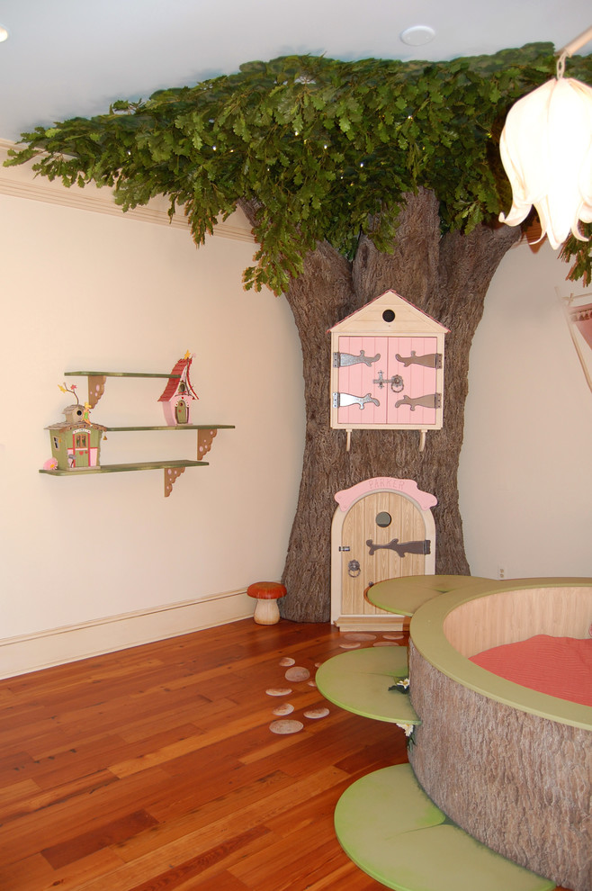 This is an example of a medium sized bohemian children’s room for girls in New Orleans with beige walls and medium hardwood flooring.