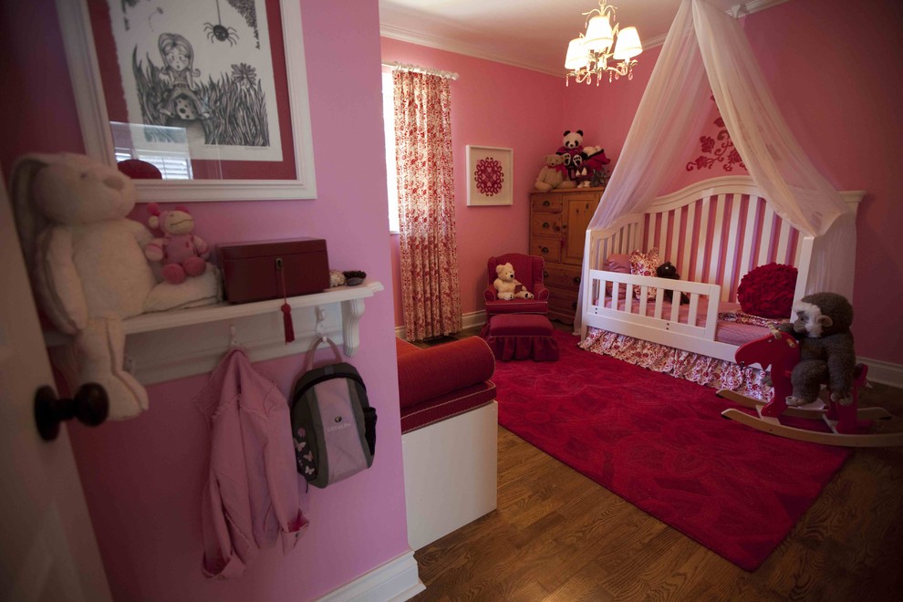Exemple d'une petite chambre d'enfant de 1 à 3 ans chic avec un mur rose et un sol en bois brun.