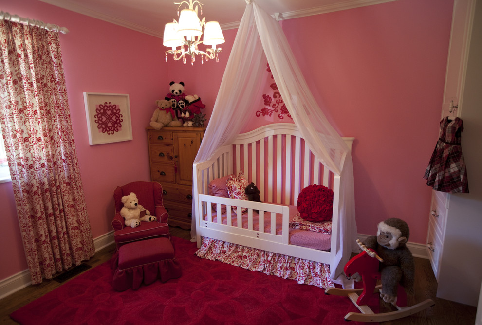 Idéer för ett litet klassiskt barnrum kombinerat med sovrum, med rosa väggar och mellanmörkt trägolv