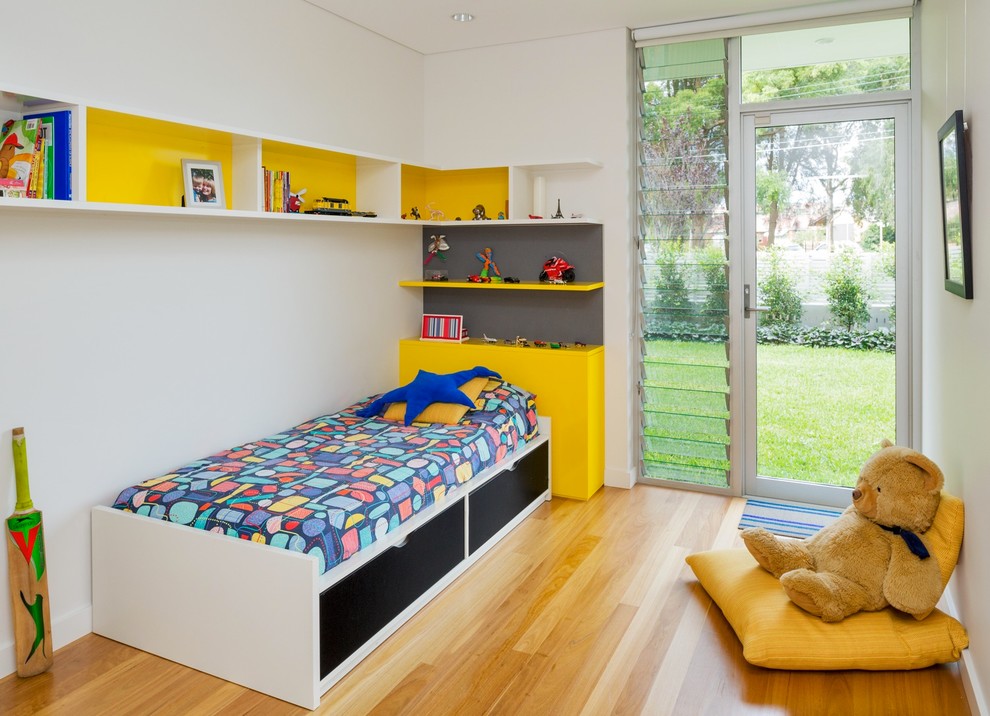 Ejemplo de dormitorio infantil de 4 a 10 años contemporáneo con paredes blancas y suelo de madera en tonos medios