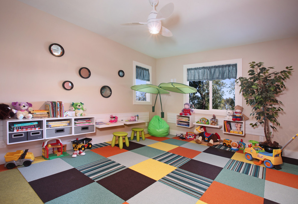 Réalisation d'une salle de jeux d'enfant design avec un mur rose, moquette et un sol multicolore.