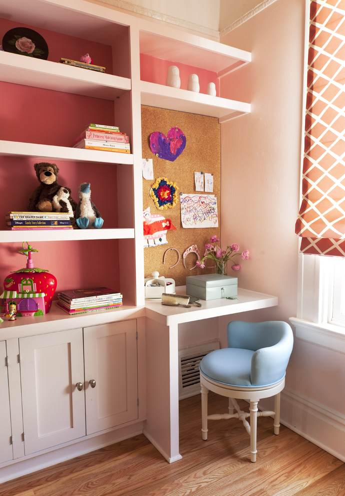 Ispirazione per una cameretta per bambini da 4 a 10 anni chic con pareti rosa e pavimento in legno massello medio