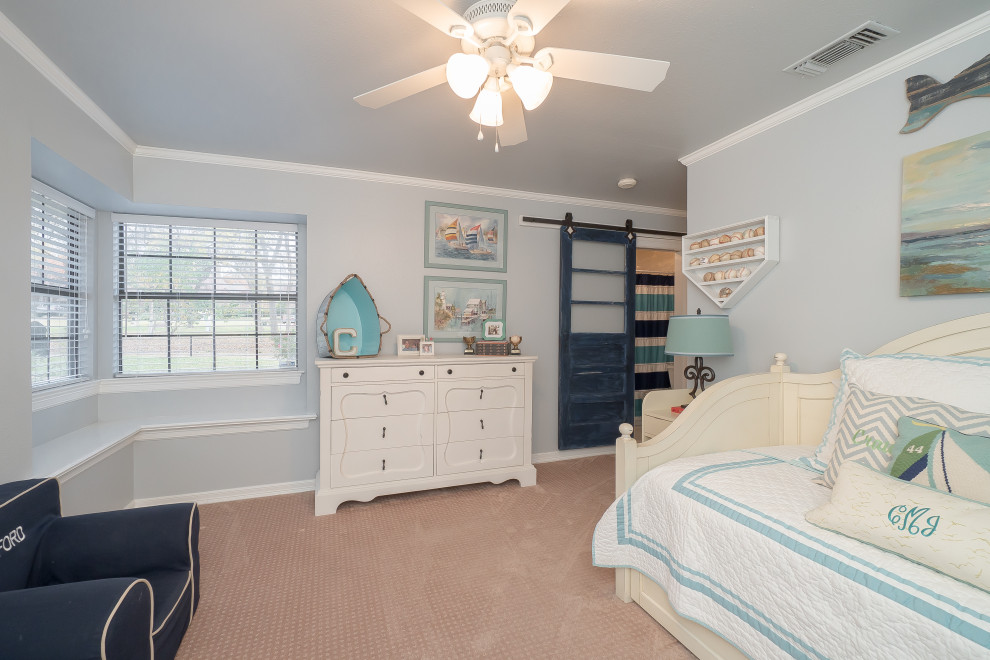 Photo of a medium sized coastal children’s room for boys in Dallas with blue walls, carpet and beige floors.
