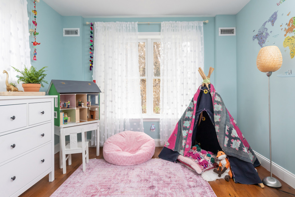 Esempio di una cameretta per bambini tradizionale con pareti blu, pavimento in legno massello medio e pavimento marrone