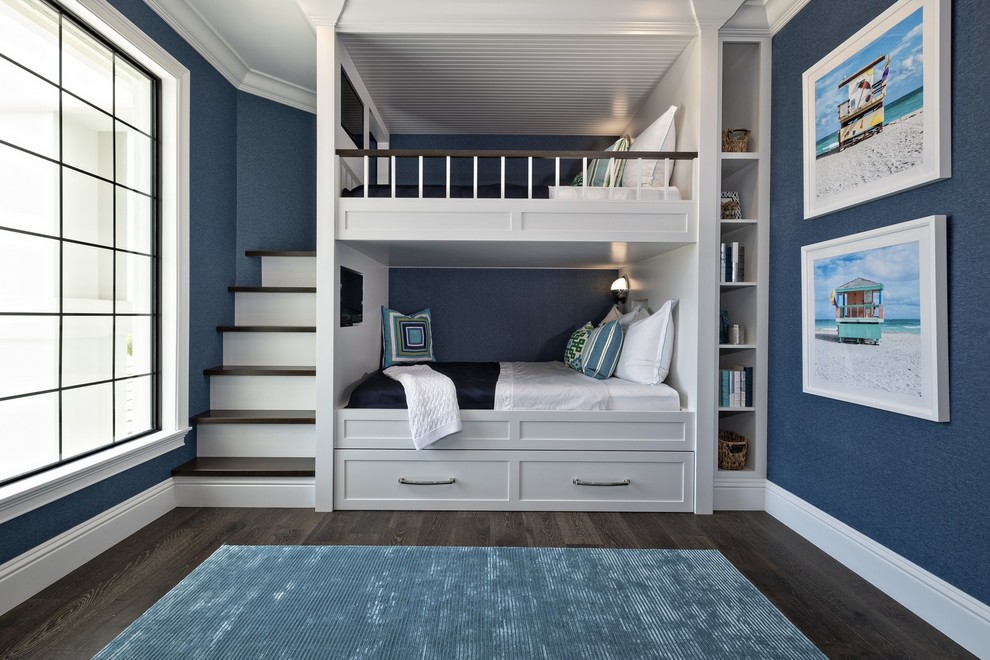 Aménagement d'une chambre d'enfant bord de mer avec un mur bleu, parquet foncé, un sol marron et un lit superposé.