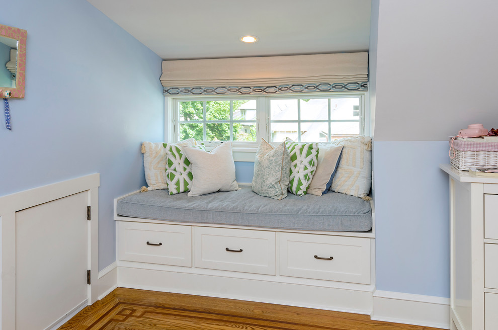 Amerikansk inredning av ett mellanstort könsneutralt barnrum kombinerat med sovrum, med blå väggar, mellanmörkt trägolv och brunt golv